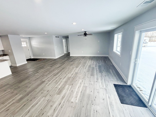 unfurnished living room featuring ceiling fan and light wood-type flooring