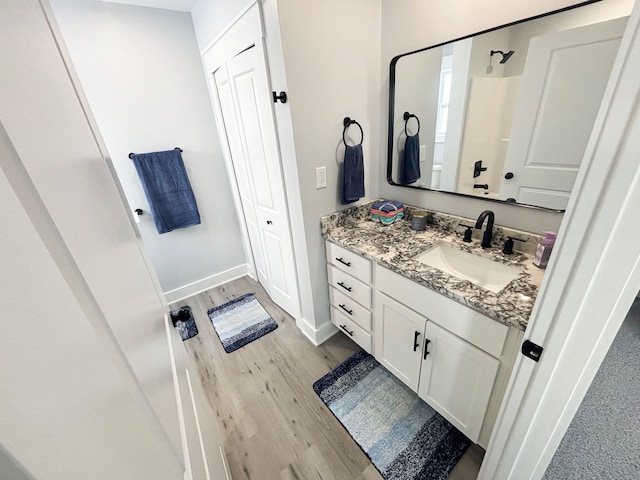 bathroom with hardwood / wood-style flooring, vanity, toilet, and a shower