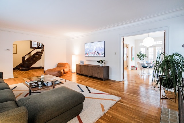 living room with crown molding and light hardwood / wood-style flooring