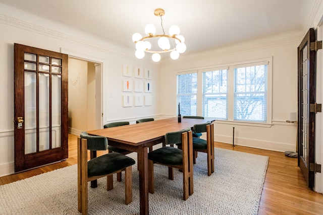 dining room featuring ornamental molding, a notable chandelier, and light hardwood / wood-style floors