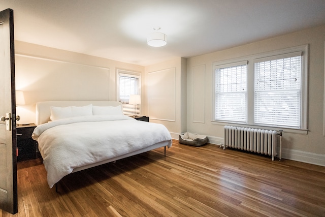 bedroom featuring radiator and hardwood / wood-style flooring