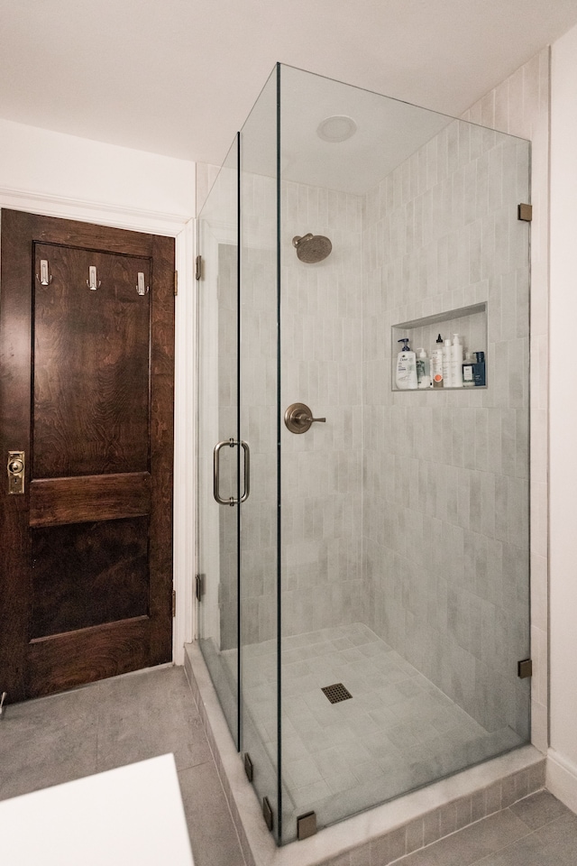 bathroom with tile patterned flooring and a shower with door