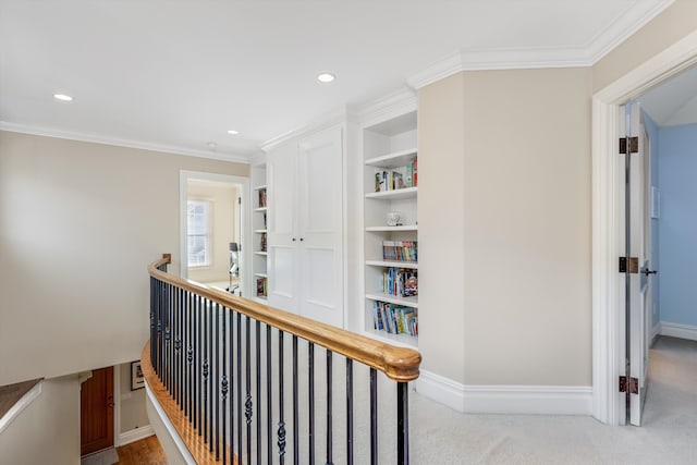 corridor featuring ornamental molding, light carpet, and built in features