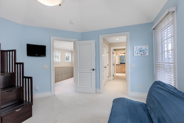 bedroom featuring multiple windows, vaulted ceiling, and light carpet