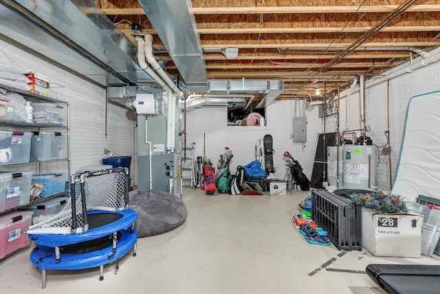 basement with heating unit, gas water heater, electric panel, and brick wall