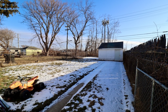 yard covered in snow featuring a storage unit