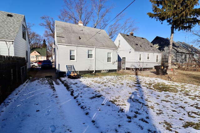 view of snow covered rear of property