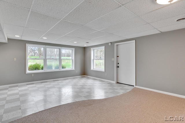 spare room with a drop ceiling and light colored carpet