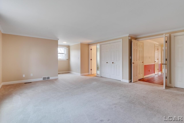 spare room with ornamental molding and light colored carpet