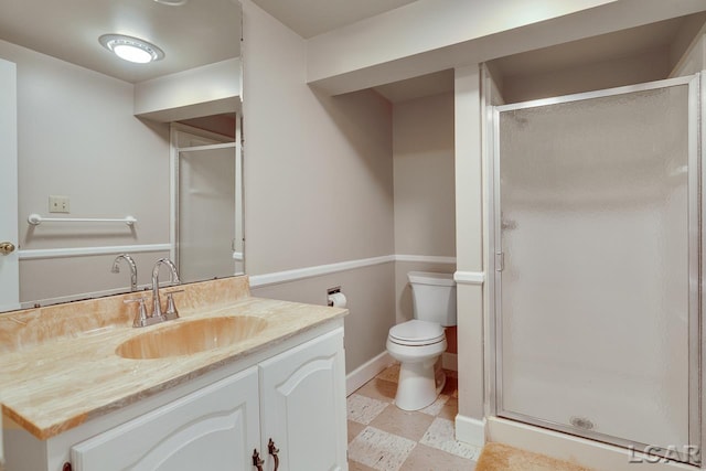 bathroom featuring vanity, toilet, and a shower with door