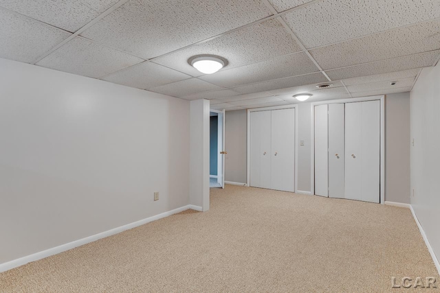 basement featuring carpet and a drop ceiling