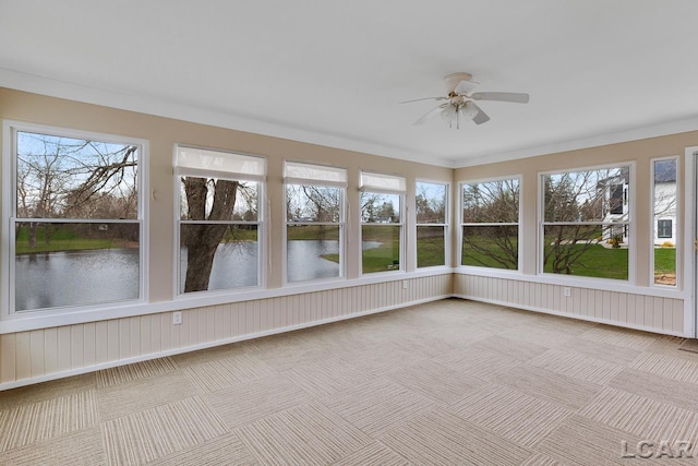 unfurnished sunroom with a water view and ceiling fan