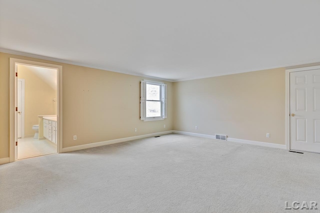 carpeted spare room featuring crown molding