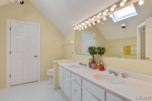 bathroom featuring toilet, vanity, and lofted ceiling with skylight