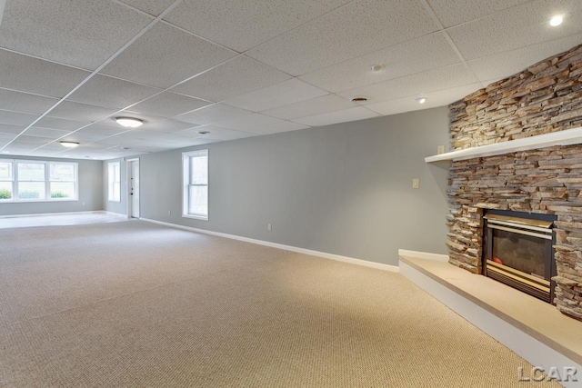 unfurnished living room with a fireplace, a paneled ceiling, and carpet flooring