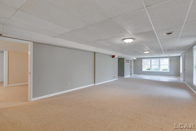 basement with a drop ceiling and carpet