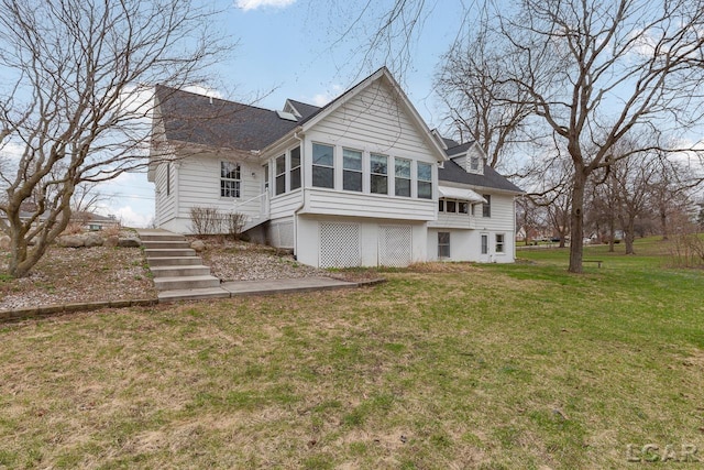 back of house with a yard and a sunroom