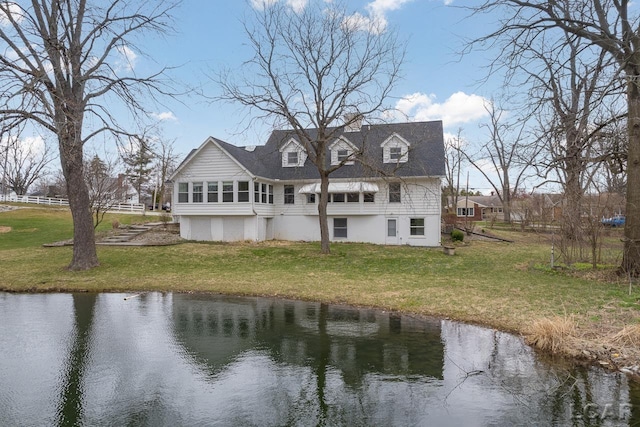 rear view of property with a water view and a yard