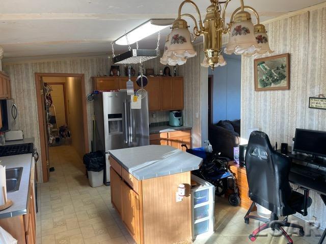 kitchen with ornamental molding, stainless steel appliances, and a center island