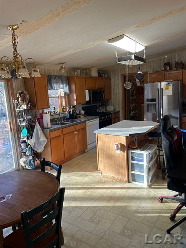 kitchen featuring sink, dishwasher, range, a kitchen island, and stainless steel fridge with ice dispenser