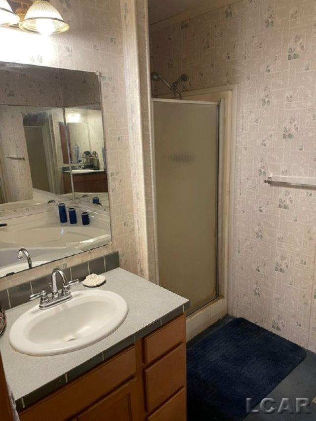 bathroom featuring vanity and an enclosed shower