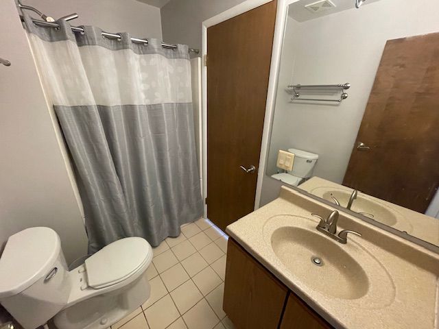 bathroom featuring tile patterned flooring, vanity, and toilet