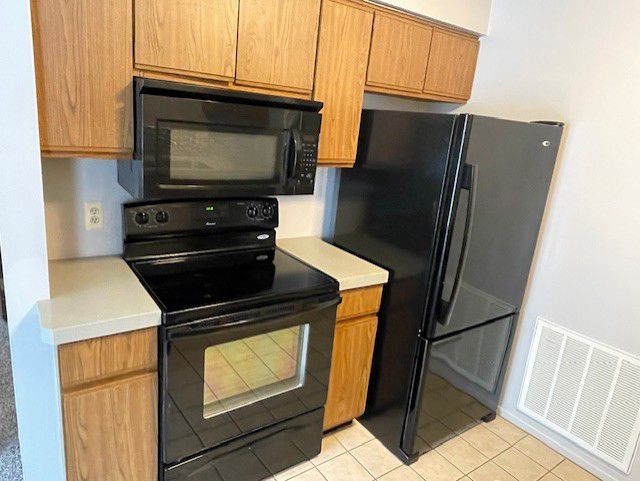 kitchen with light tile patterned floors and black appliances