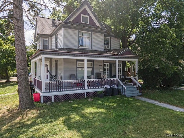 victorian house featuring covered porch and a front lawn