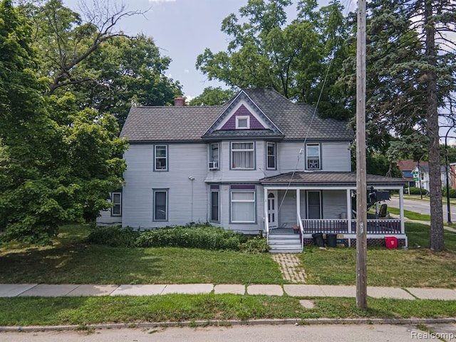 victorian-style house featuring a porch and a front yard