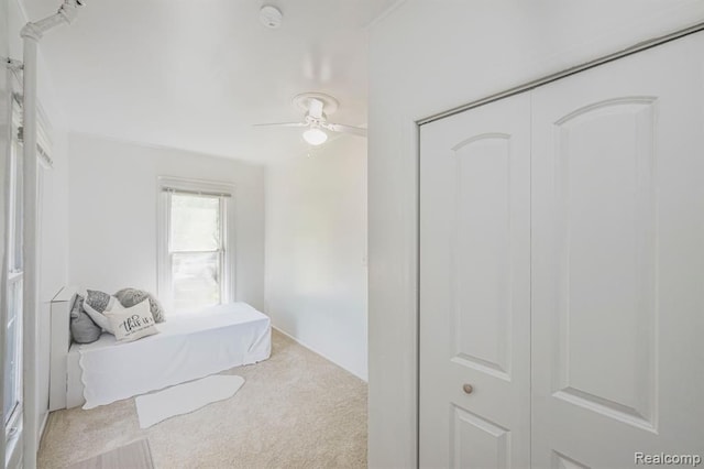 carpeted bedroom featuring ceiling fan and a closet