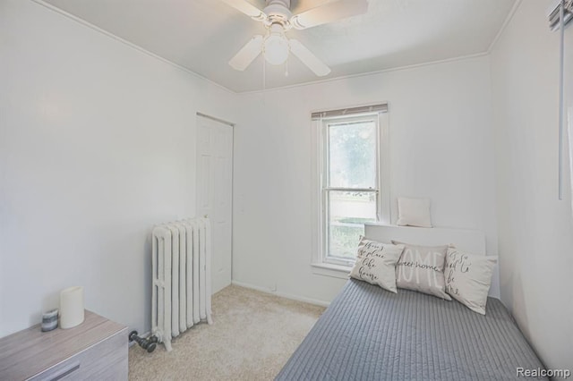 bedroom with light carpet, radiator heating unit, and ceiling fan