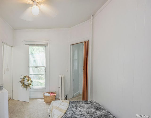 bedroom with multiple windows, light carpet, radiator heating unit, and ceiling fan