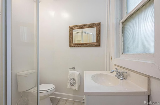 bathroom featuring vanity, toilet, tile patterned flooring, and plenty of natural light