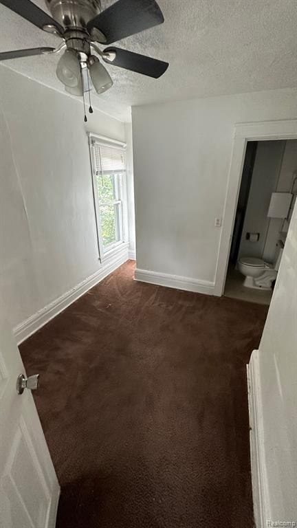 carpeted spare room featuring ceiling fan and a textured ceiling