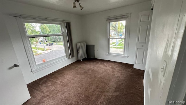 carpeted empty room featuring radiator