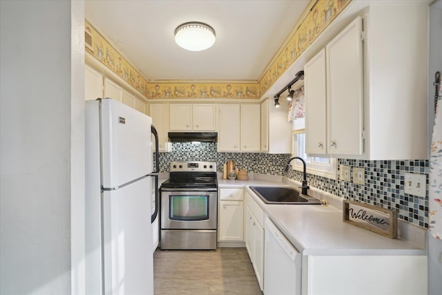 kitchen featuring tasteful backsplash, sink, white cabinets, and white appliances