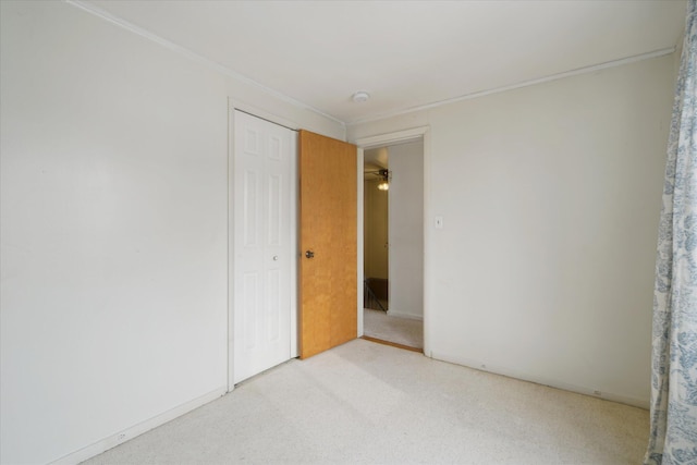 unfurnished room featuring ornamental molding and light carpet