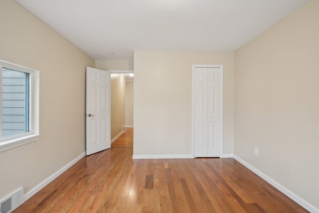 unfurnished bedroom with wood-type flooring and a closet