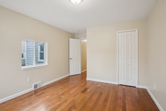 unfurnished bedroom with light wood-type flooring and a closet