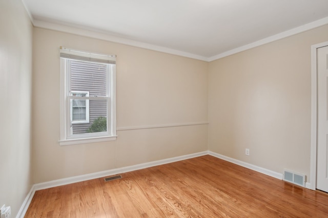 spare room featuring crown molding and wood-type flooring