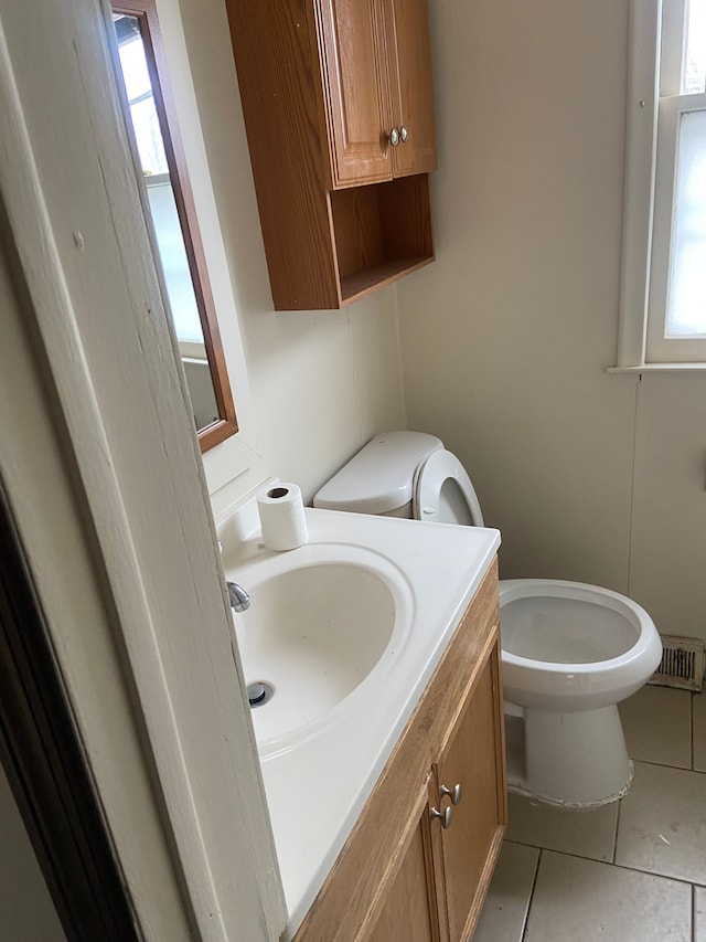 bathroom featuring tile patterned flooring, vanity, and toilet