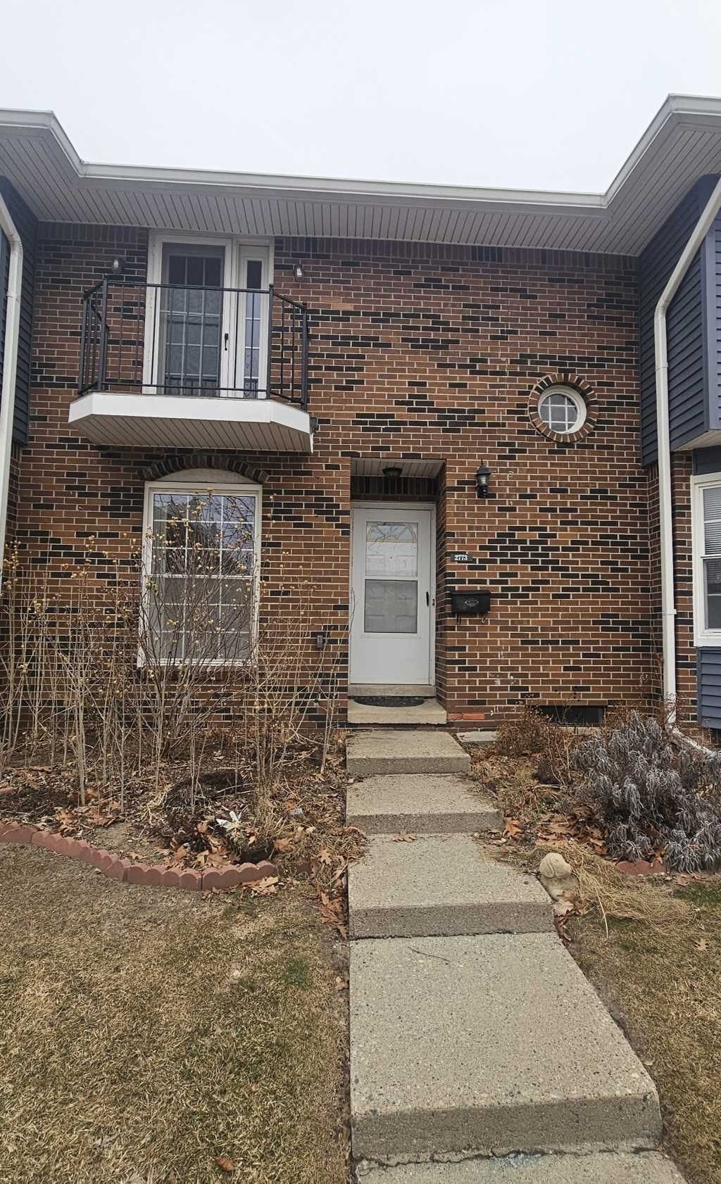 doorway to property featuring a lawn and a balcony