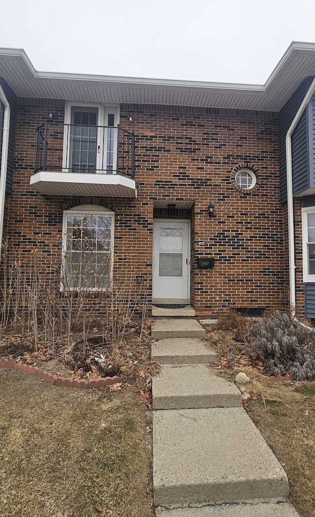 doorway to property featuring a lawn and a balcony