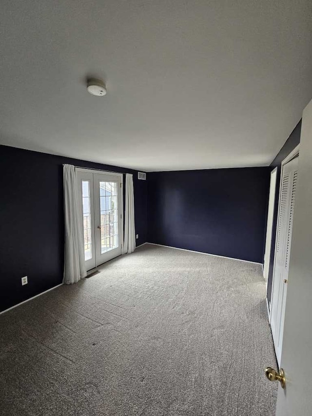 carpeted empty room featuring french doors