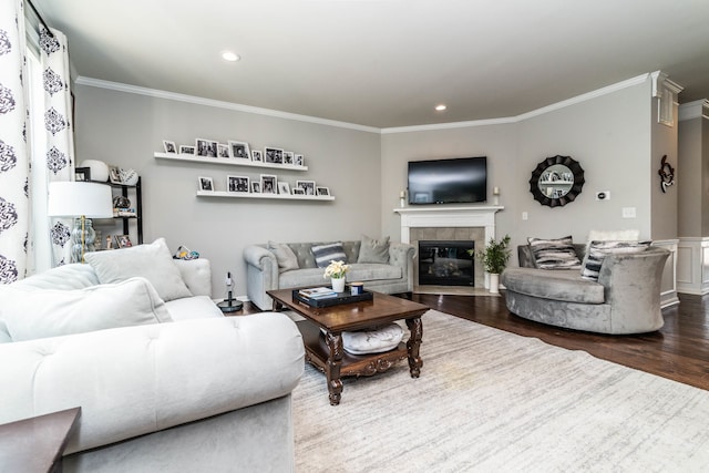 living room featuring dark hardwood / wood-style flooring, crown molding, and a tile fireplace