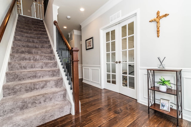 stairs with wood-type flooring, ornamental molding, and french doors