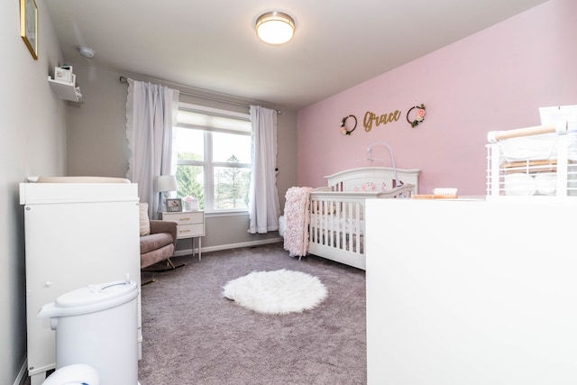 bedroom with a nursery area and dark carpet