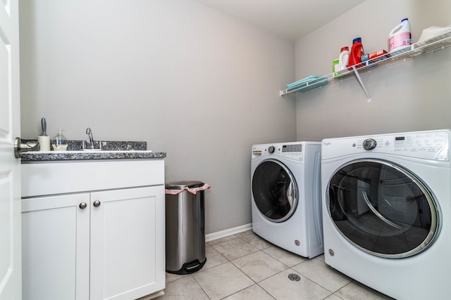 laundry area with sink, washer and clothes dryer, cabinets, and light tile patterned flooring