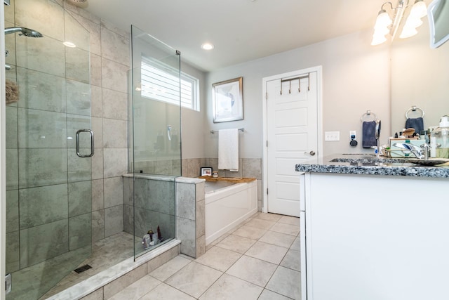 bathroom featuring an inviting chandelier, tile patterned floors, a shower with shower door, and vanity