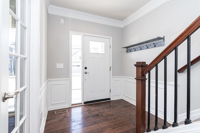 foyer entrance with dark wood-style floors, visible vents, stairway, and ornamental molding